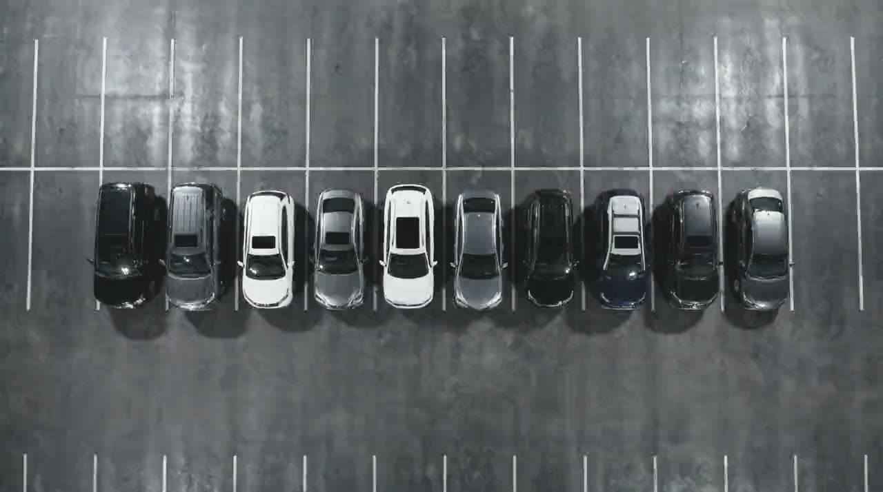 The fleet photographed from directly overhead, parked in a single line across marked bays.